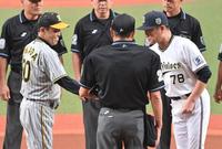 　中嶋監督（右）とメンバー表交換で握手する岡田監督（撮影・西岡正）