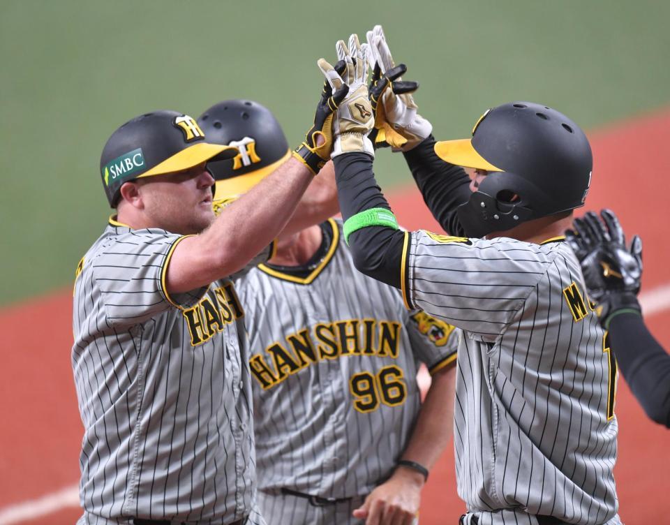 　４回、先制３ランを放ち、森下（右）とハイタッチするノイジー（撮影・西岡正）