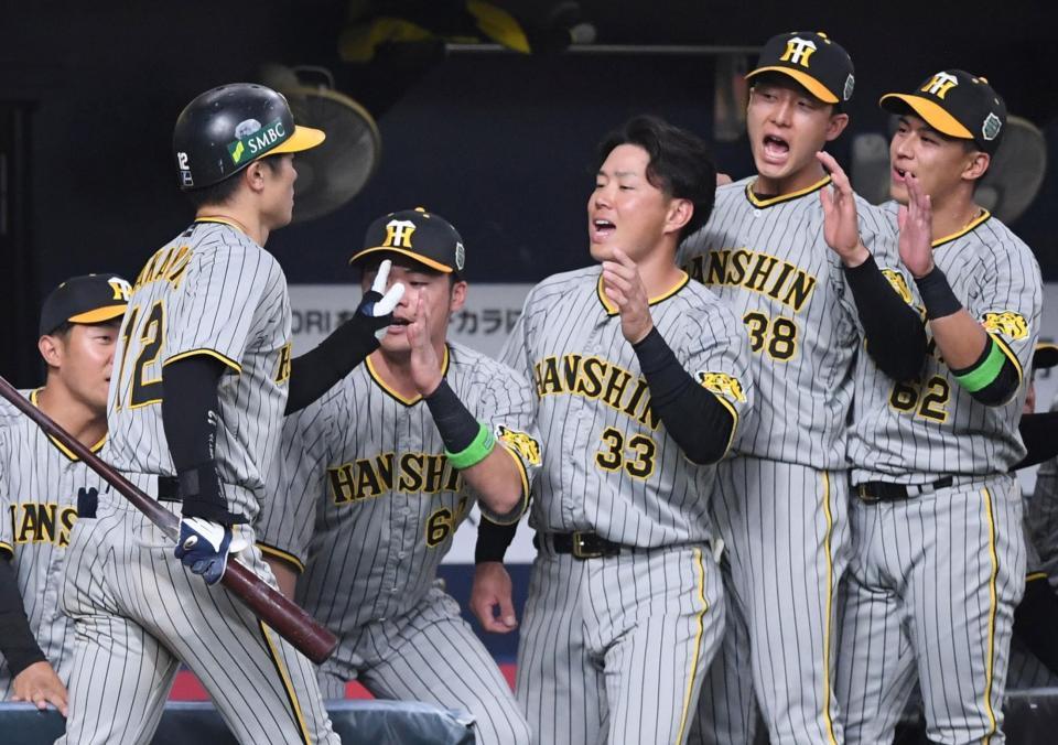 　６回、犠打を決めた坂本（左）を迎える糸原（右から３人目）らナイン（撮影・中田匡峻）
