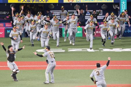 　日本シリーズ優勝が決まった瞬間、ベンチから勢いよく飛び出す阪神ナイン（撮影・立川洋一郎）