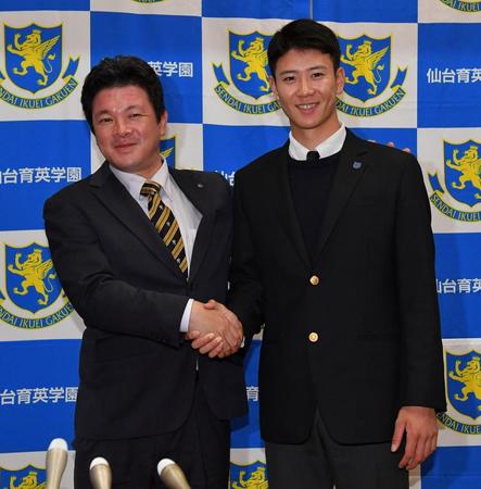 　阪神から指名あいさつを受け、須江航監督（左）と笑顔で握手を交わす仙台育英・山田脩也（撮影・出月俊成）