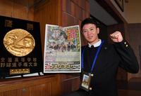 　デイリースポーツの日本一紙面と自身の甲子園優勝盾と並んで意気込みを見せた阪神３位・山田（撮影・出月俊成）