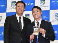 　平塚スカウト（左）から岡田監督のサインが入ったドラフト会議のＩＤを手渡された福島（撮影・佐々木彰尚）