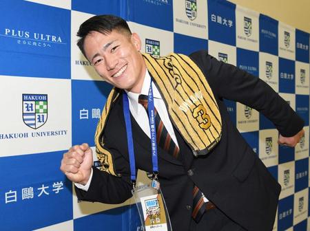 　大学の先輩・大山のタオルをかけてポーズを決める育成２位指名の白鷗大・福島（撮影・佐々木彰尚）