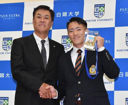 　平塚スカウト（左）から岡田監督のサインが入ったドラフト会議のＩＤを手渡された福島（撮影・佐々木彰尚）