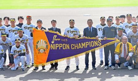 　優勝報告セレモニーで日本シリーズ優勝ペナントを手に地元関係者と記念撮影をする岡田監督（中央）ら阪神ナイン（撮影・立川洋一郎）