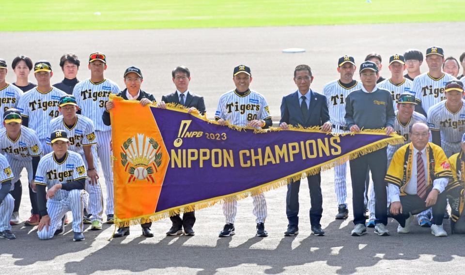 　優勝報告セレモニーで日本シリーズ優勝ペナントを手に地元関係者と記念撮影をする岡田監督（中央）ら阪神ナイン（撮影・立川洋一郎）
