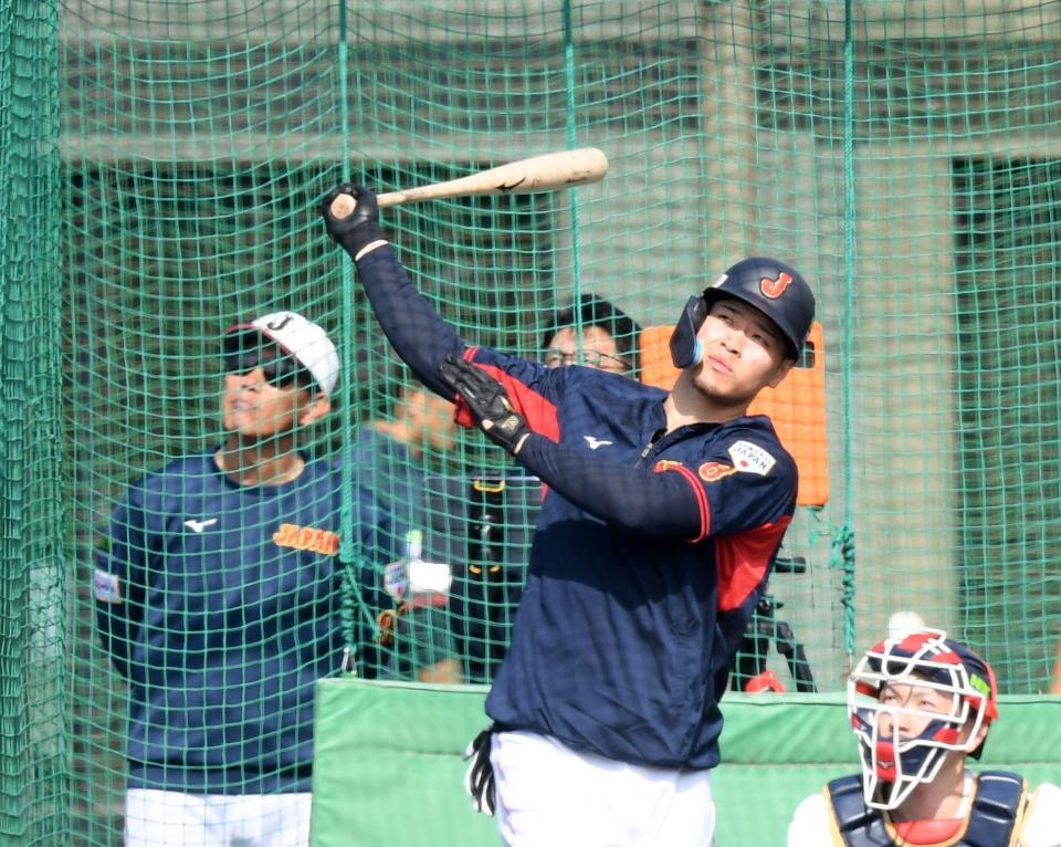 　打撃練習をする佐藤輝と打球の行方を見つめる井端監督（撮影・中田匡峻）