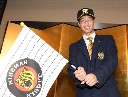 　仮契約を終え、笑顔でポーズを決めるドラフト４位の百崎（撮影・石井剣太郎）