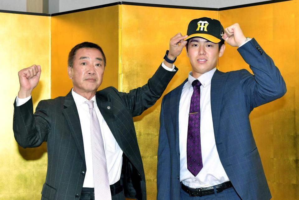 　仮契約を終えた阪神ドラフト５位の石黒は山本スカウト（左）とポーズを決める（撮影・石井剣太郎）