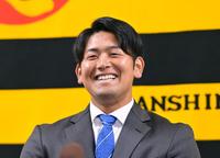 　契約更改を終えて会見に臨み笑顔を見せる岡留（撮影・立川洋一郎）