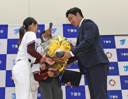 　下妻市観光大使に就任し少年時代在籍していた宗道ニューモンキーズの子どもたちから花束を手渡され笑顔をみせる大山（右）＝撮影・三好信也