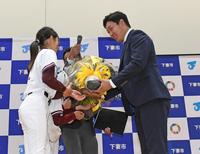　下妻市観光大使に就任し少年時代在籍していた宗道ニューモンキーズの子どもたちから花束を手渡され笑顔をみせる大山（右）＝撮影・三好信也