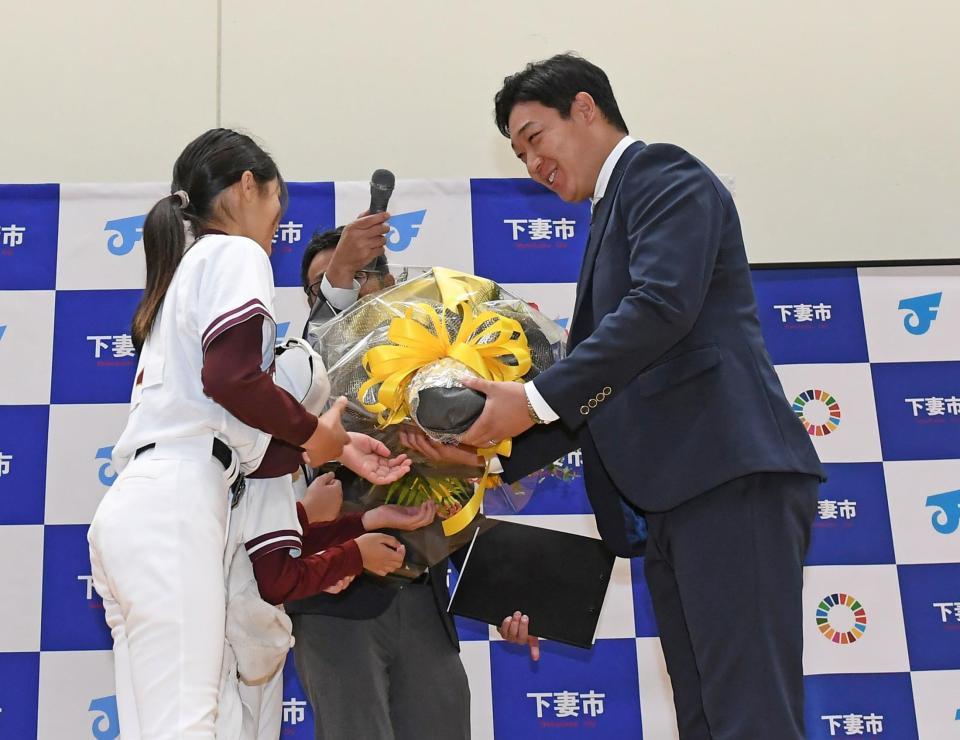 　下妻市観光大使に就任し少年時代在籍していた宗道ニューモンキーズの子どもたちから花束を手渡され笑顔をみせる大山（右）＝撮影・三好信也