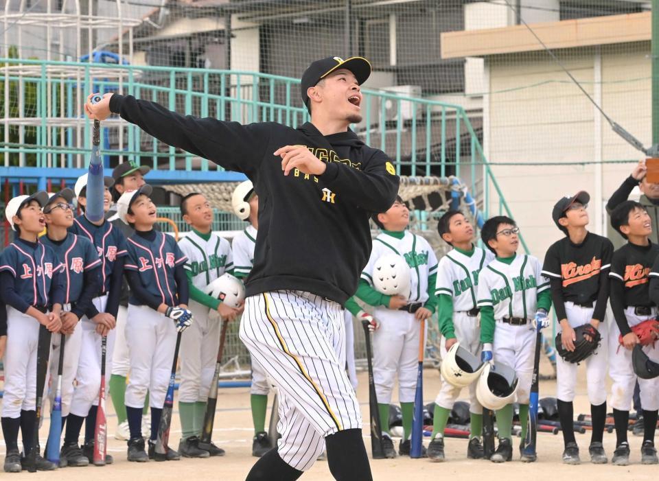 　少年少女の前で豪快なロングティーを披露する佐藤輝（撮影・高部洋祐）