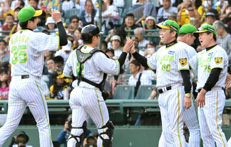 ロッテに連勝し、阪神・才木浩人（左端）らナインとタッチを交わす阪神・岡田彰布監督（８０）＝撮影・高部洋祐