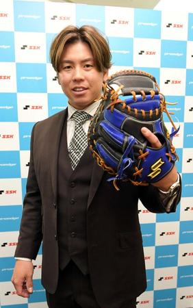 　来季使用するミットを手にする梅野（撮影・北村雅宏）