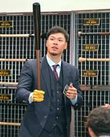 　バットを手にして感触を確かめる佐藤輝（撮影・立川洋一郎）