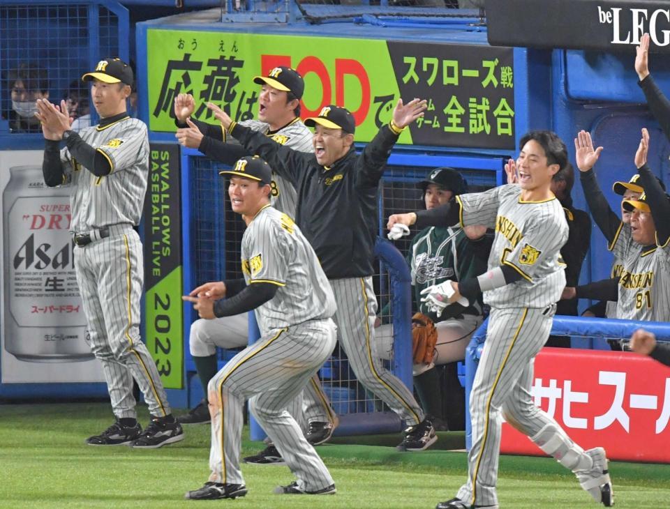 　９回、佐藤輝の勝ち越し二塁打でベンチを飛び出して喜ぶ岡田監督（中央）ら阪神ナイン＝２３年５月
