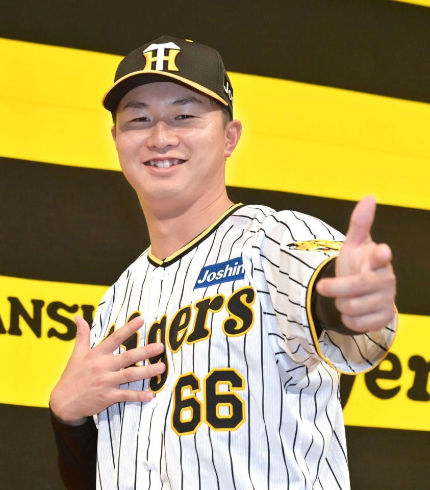 　「ゴイゴイスー」のポーズで笑顔を見せる津田