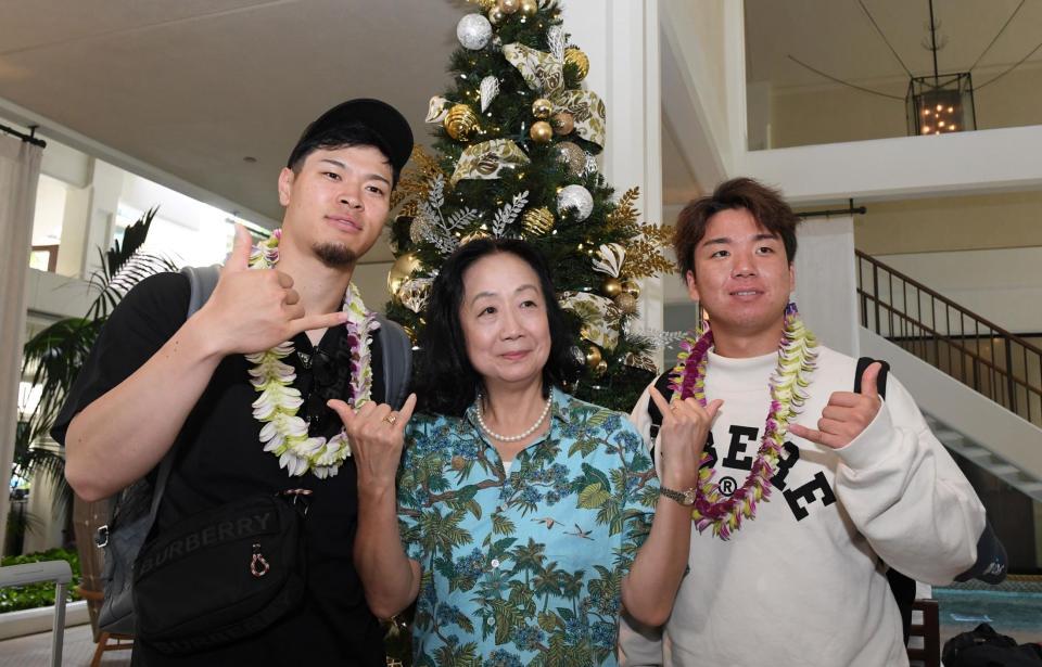 　ホテルに到着し、関係者と写真に納まる佐藤輝（左）と村上（右）＝撮影・中田匡峻