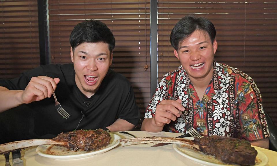 　肉に食らいつく佐藤輝（左）と森下