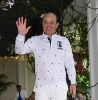 　優勝旅行を満喫した岡田監督は笑顔で手を振りながら引き揚げる（１９日撮影）