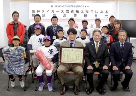 　野球用品を贈呈し、記念写真におさまる岩貞（前列中央）ら＝熊本県益城町提供