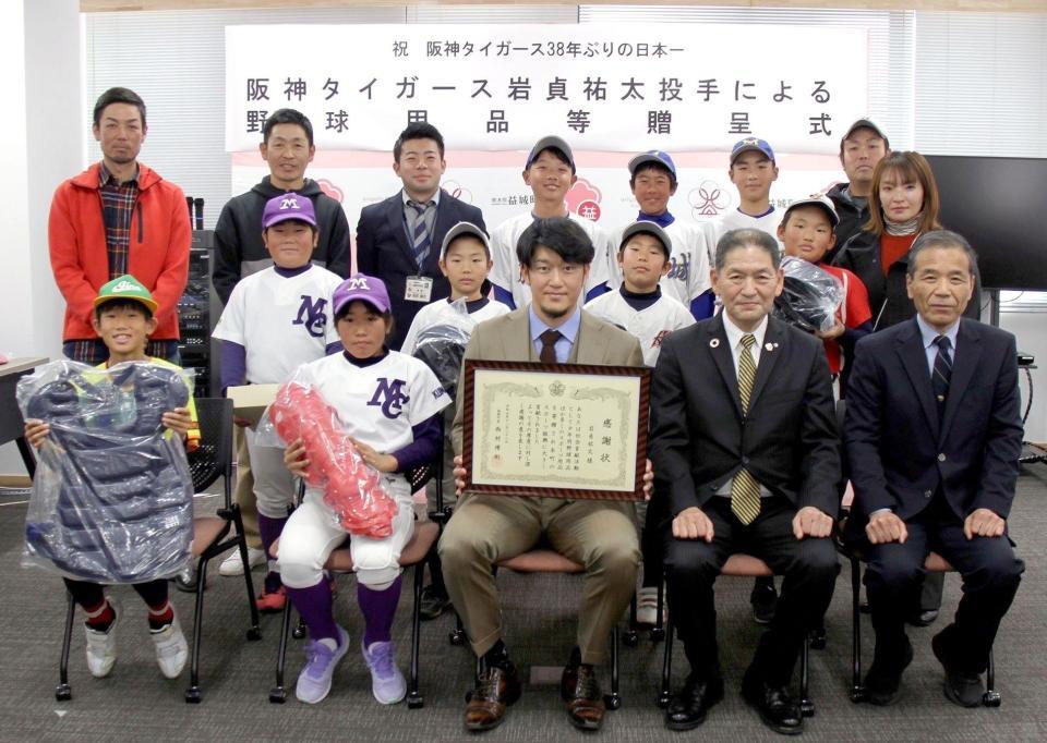 　野球用品を贈呈し、記念写真におさまる岩貞（前列中央）ら＝熊本県益城町提供