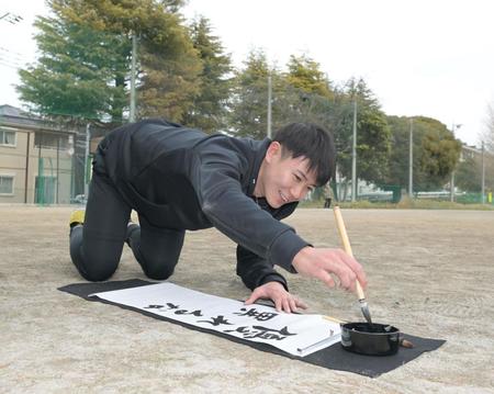 　グラウンドで書き初めをする山田（撮影・金田祐二）