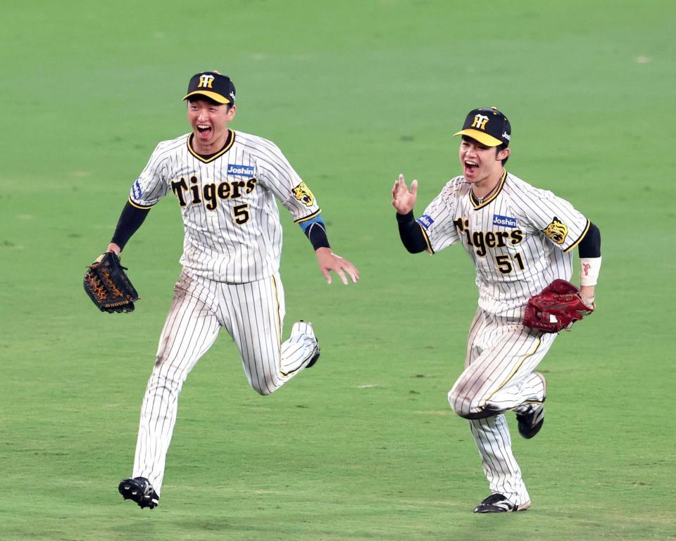 　リーグ優勝を決めて歓喜の輪に加わる（左から）近本と中野