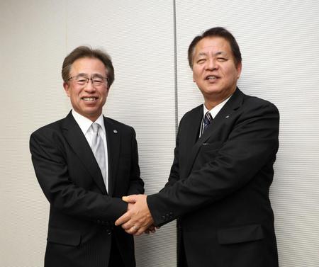 　デイリースポーツ本社を訪れた粟井球団社長（左）は笑顔でデイリースポーツ・藤谷社長と握手を交わす