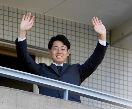 　入寮し、ベランダから手を振る下村（撮影・田中太一）