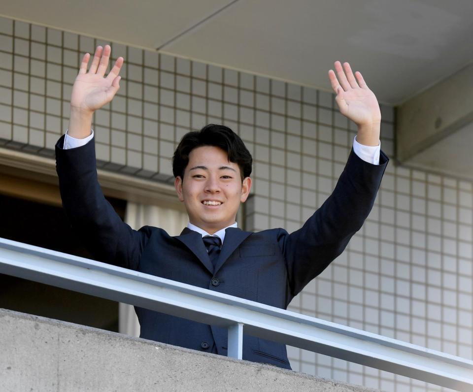 　入寮し、ベランダから手を振る下村（撮影・田中太一）