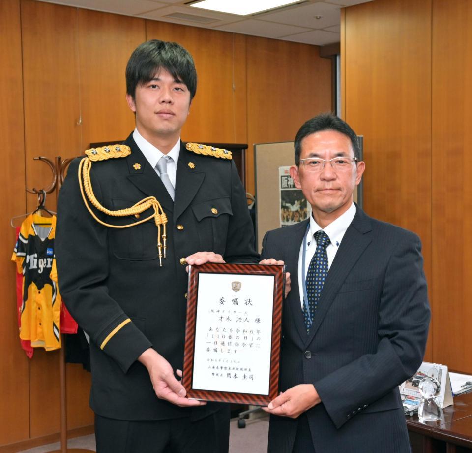 　岡本圭司・兵庫県警察本部地域部長（右）から一日通信司令官の委嘱状を受け取る才木（撮影・立川洋一郎）