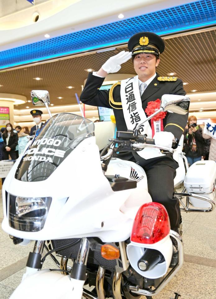 　白バイに乗って敬礼する才木（撮影・立川洋一郎）