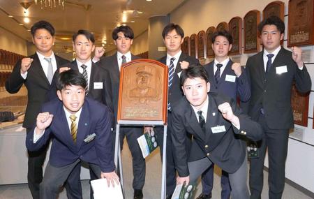 　バース氏のレリーフを囲み記念撮影する（後列右から）椎葉、下村、津田、石黒、福島、松原（前列右から）山田、百崎ら阪神の新人選手たち（代表撮影）
