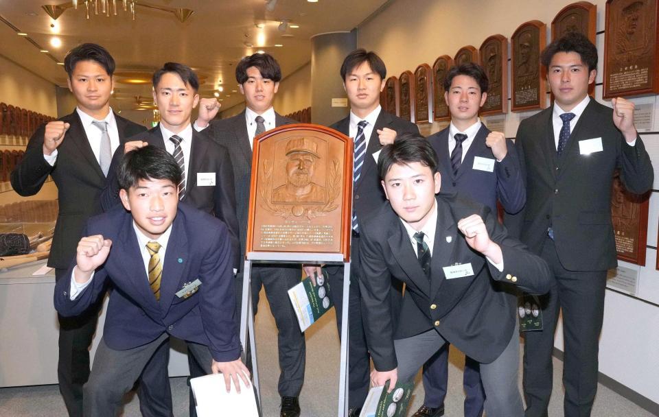 　バース氏のレリーフを囲み記念撮影する（後列右から）椎葉、下村、津田、石黒、福島、松原（前列右から）山田、百崎ら阪神の新人選手たち（代表撮影）