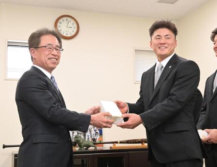 　２０歳記念品贈呈式に臨み、粟井球団社長（左）から記念品を受け取る前川（撮影・立川洋一郎）