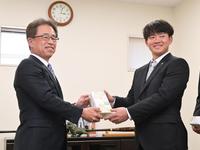 　２０歳記念品贈呈式に臨み、粟井球団社長（左）から記念品を受け取る中川（撮影・立川洋一郎）