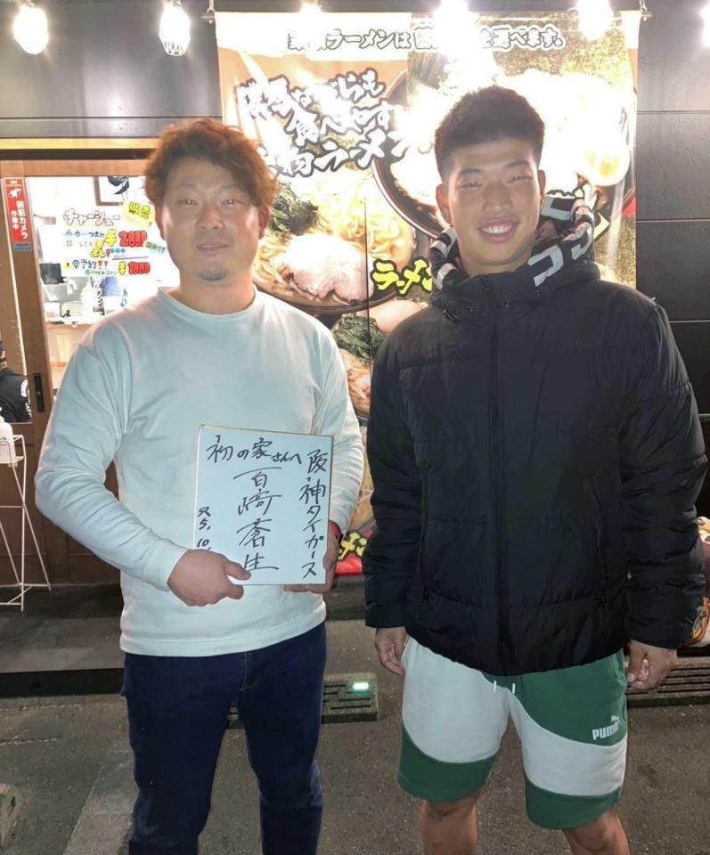 　百崎と記念撮影する本田さん（左）