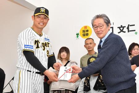 　寄付を贈呈する原口（左）。右は堀内まさみ理事長（撮影・中田匡峻）