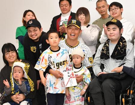 　施設のこどもたちや親御さんと写真を撮る原口（中央）＝撮影・中田匡峻