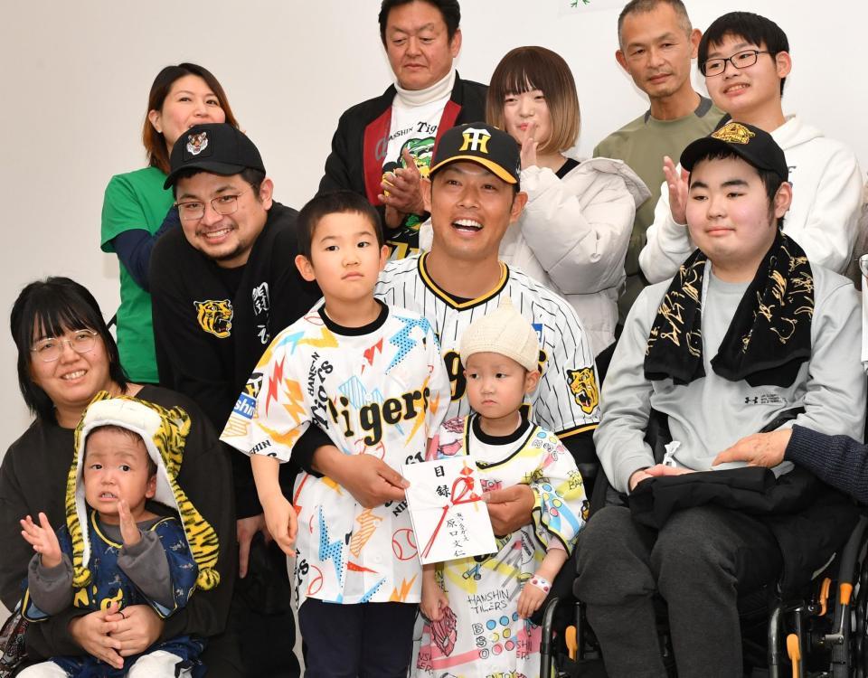 　施設のこどもたちや親御さんと写真を撮る原口（中央）＝撮影・中田匡峻