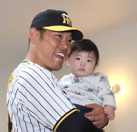 　こどもを抱っこし、笑顔を見せる原口