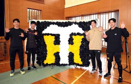 　子どもたちが作った応援ボードの前でポーズを決める（左から）茨木、門別、湯浅、小幡