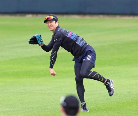 　シートノックの打球を処理して送球する近本（撮影・立川洋一郎）