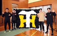 　子どもたちが作った応援ボードの前でポーズを決める（左から）茨木、門別、湯浅、小幡