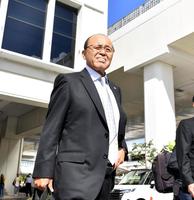 　沖縄の強い日差しを浴びながら、車に向かう岡田監督（撮影・中田匡峻）