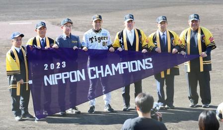 　宜野座村にチャンピオンフラッグのレプリカを贈呈し、記念撮影に納まる岡田監督ら（撮影・立川洋一郎）